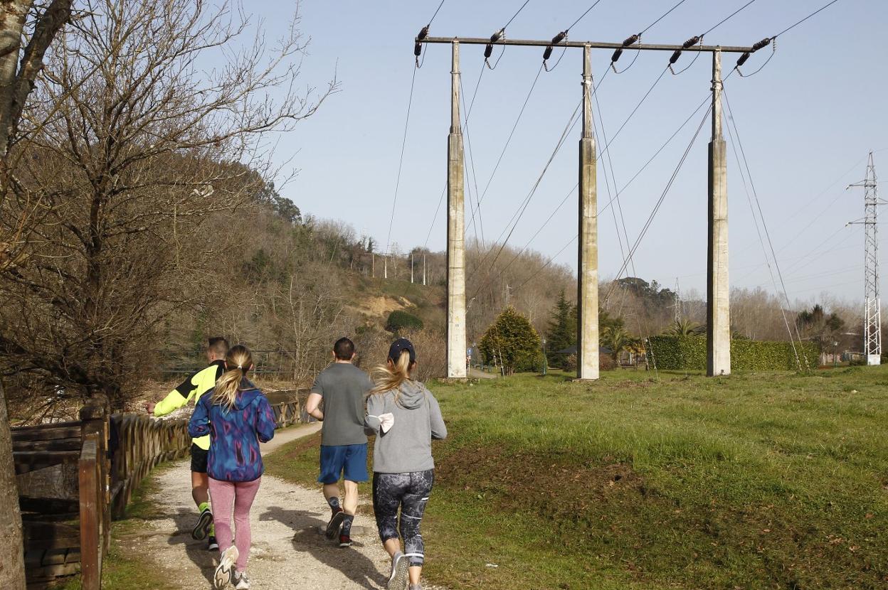 Un grupo de jóvenes corre entre la finca que se destinará al área de servicio y la línea eléctrica de alta tensión. 