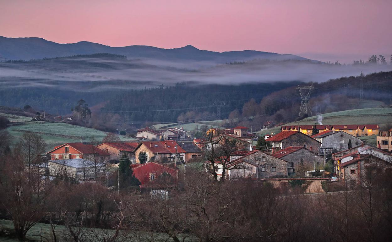 La niebla al amanecer, con el monte al fondo, sobre la localidad de El Llano, en el municipio de Udías