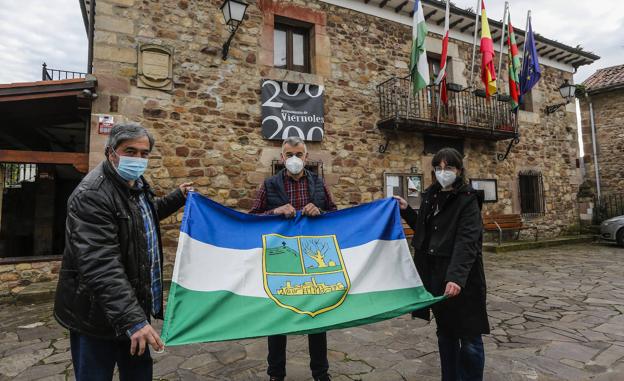 Jesús García, Eduardo Truebay Sara del Hoyo muestran la bandera local. 