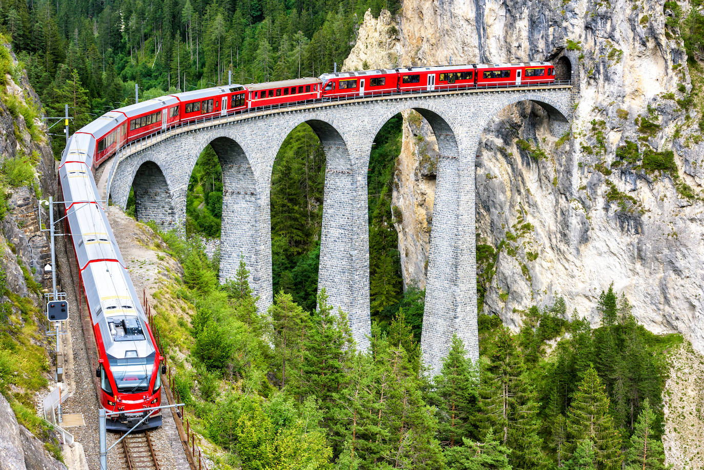 El Bernina Express, en Suiza. Es otro de los trenes que no puedes perderte si visitas el país helvético. Son 144 kilómetros entre la localidad helvética de Coira y la pequeña localidad italiana de Tirano. En las cuatro horas y media que dura el viaje atraviesa 55 túneles y 196 puentes, entre ellos el viaducto de Landwasser, de 65 metros de altura. También permite contemplar otros lugares no menos espectaculares, como la curva de Montebello, con vistas al macizo de Bernina.