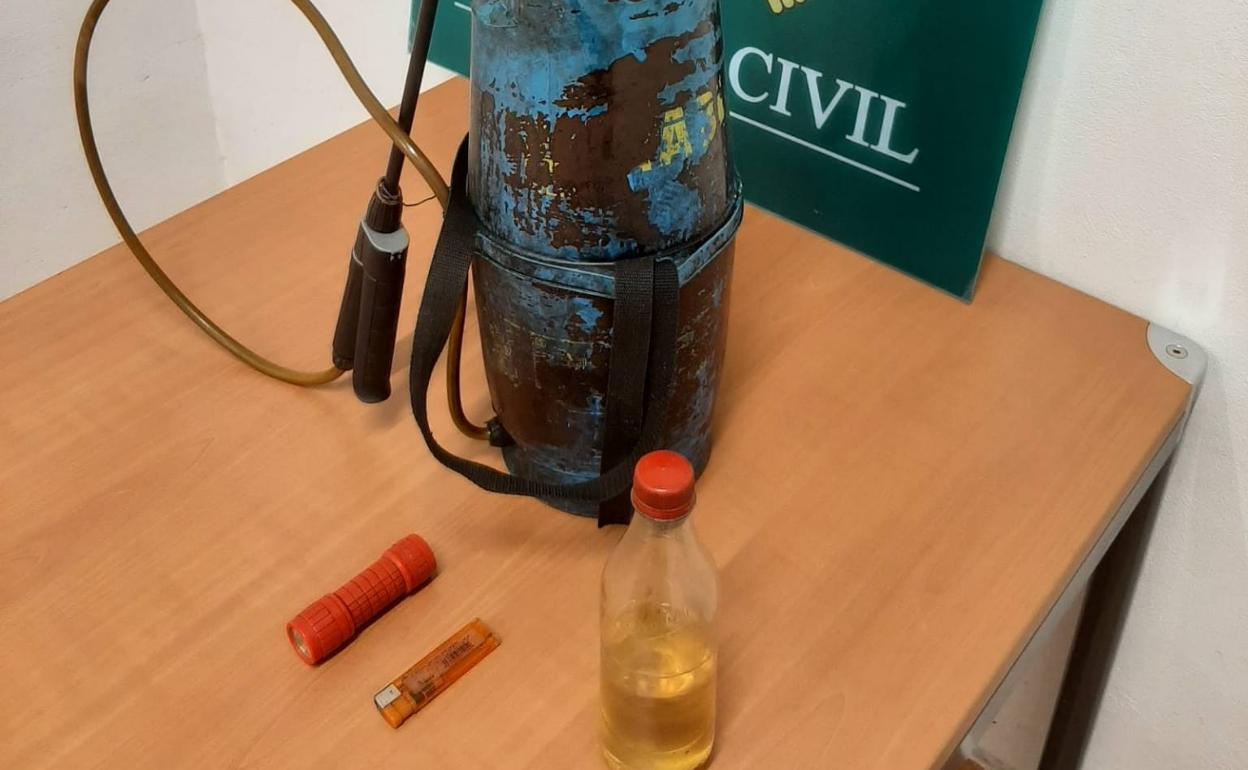 Fotografía cedida por la Guardia Civil en la que se aprecia el fumigador, la botella con gasolina, el mechero y la linterna. 