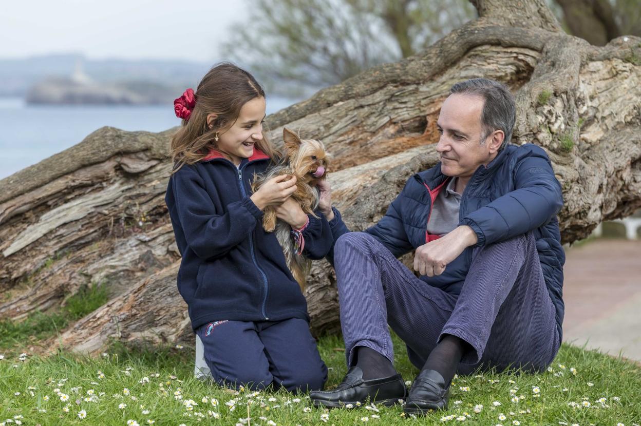 El exdelegado del Gobierno en Cantabria, Samuel Ruiz, posa en El Sardinero con su hija Triana y Lola, la 'reina de la casa'. 