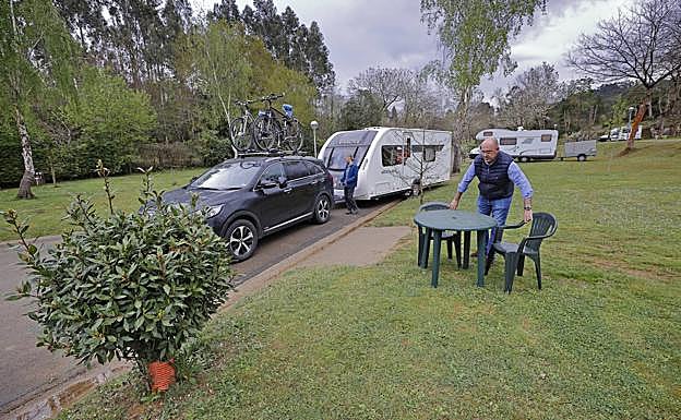 PabloAlonso coloca varias sillas en una parcela de su camping Playa de Oyambre. 