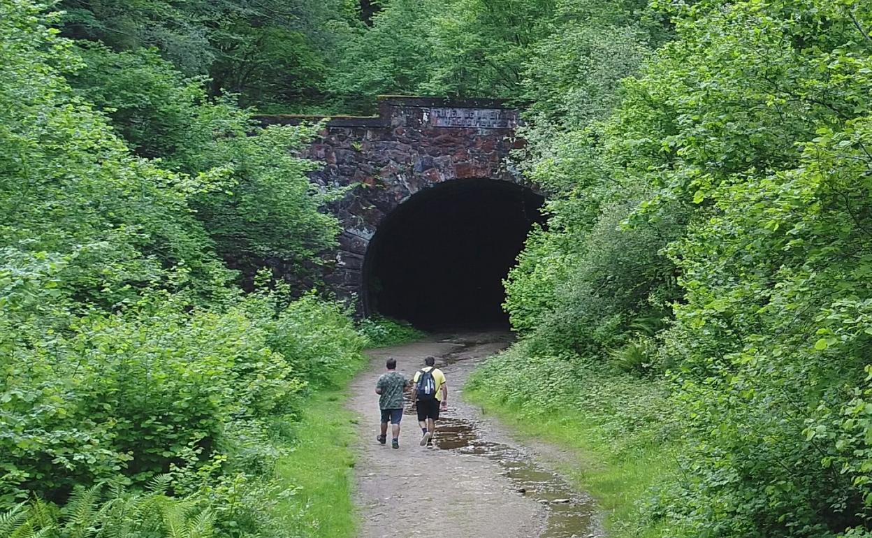 Dos excursionistas acceden al túnel de La Engaña, donde se desarrollará un proyecto con fondos UE. 