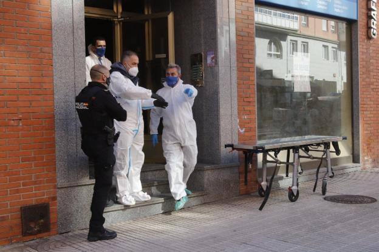 Agentes de la Científia y de la Nacional, en el portal donde sucedió el crimen, el pasado martes. 