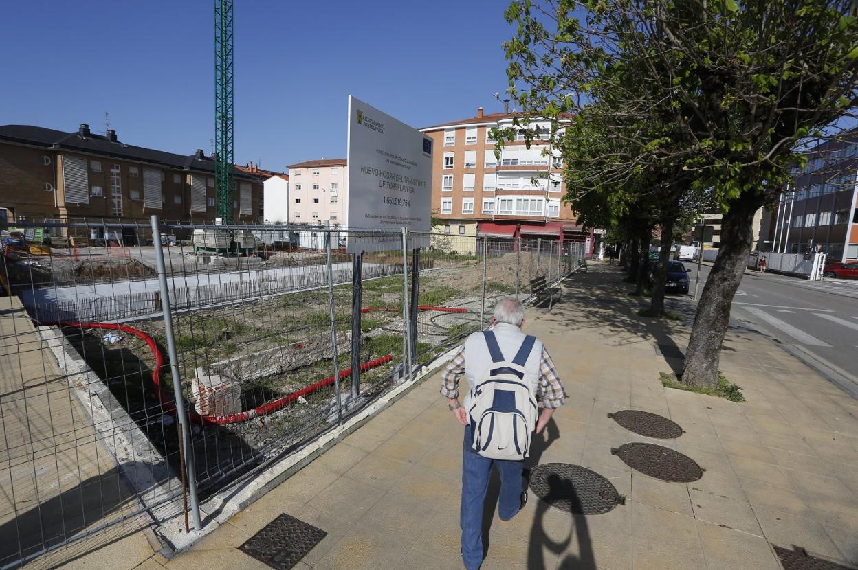 Un hombre camina junto a las obras del nuevo Hogar del Transeúnte, en la calle Pablo Garnica de Torrelavega. 