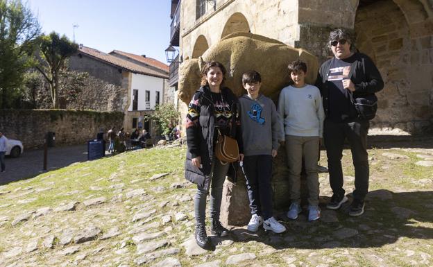 La familia Alcaya Marín, Gema, Mateo, Nicolás y Jesús, posan junto al bisonte de Jesús Otero.