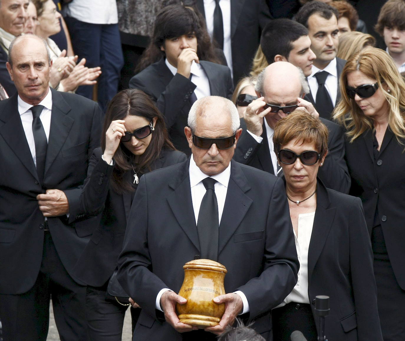 Los hermanos de Severiano Ballesteros, Baldomero (d), Vicente (i) y Manolo (c), acompañados por otros familiares, salen de la iglesia parroquial de San Pedro en Pedreña, con los restos del golfista, tras finalizar el funeral por Seve