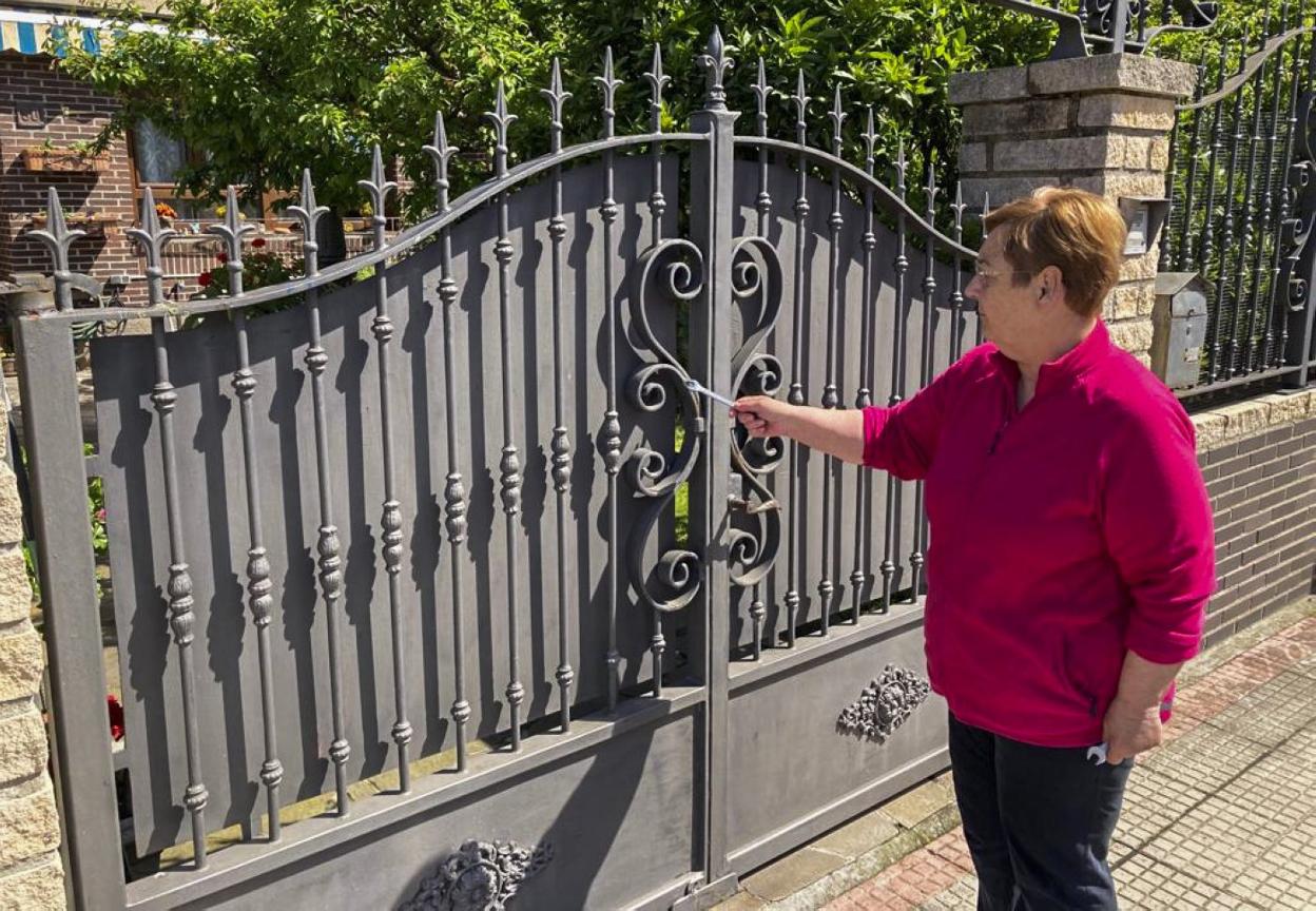 Carmen Santos, vecina del chalé 30 del barrio Isla del Oleo, muestra donde le marcaron la puerta. 