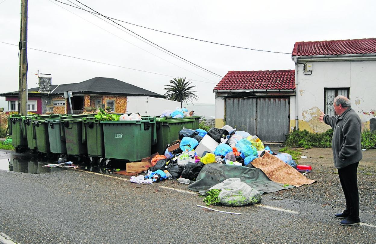 Un vecino señala la basura acumulada en el barrio El Faro de Ajo, en Bareyo. A. C.