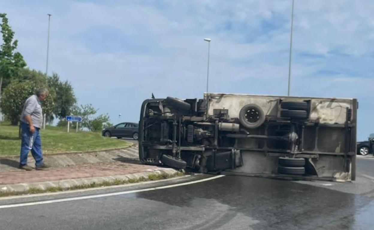 El camión, volcado en la rotonda y el aceite derramado tras el accidente.