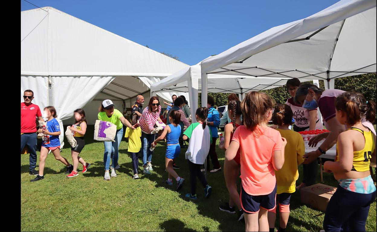 Varios niños y niñas recogen sus premios en el Trail Infantil Solidario Villa de Comillas. 