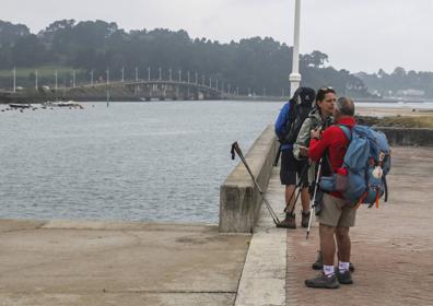 Imagen secundaria 1 - Arriba la pasarela del puente, donde se va a incluir el carril bici; abajo peregrinos con el puente de Somo al fondo; y a la derecha detalle del estado actual de uno de los pilares 