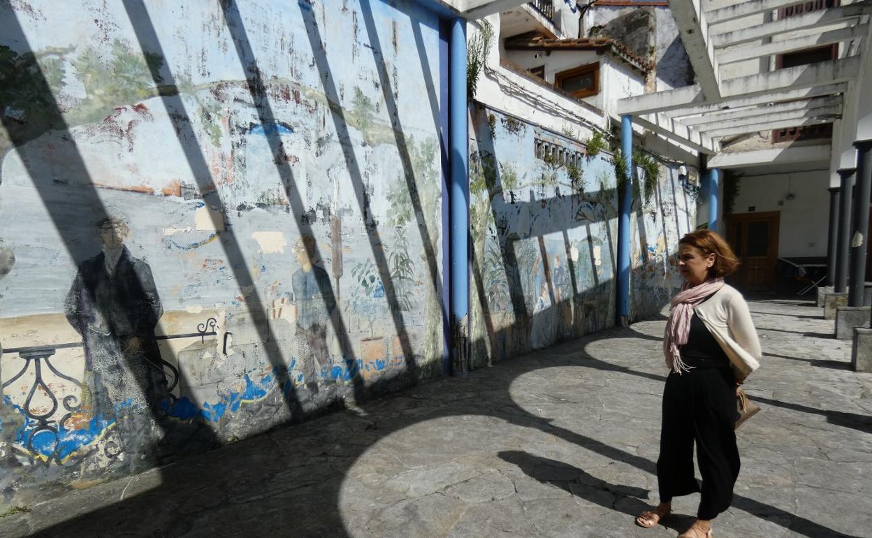 Montse Villanueva contempla el deteriorado mural de la plazoleta Marqués de Albaida, en cuya ejecución invirtió tres meses.