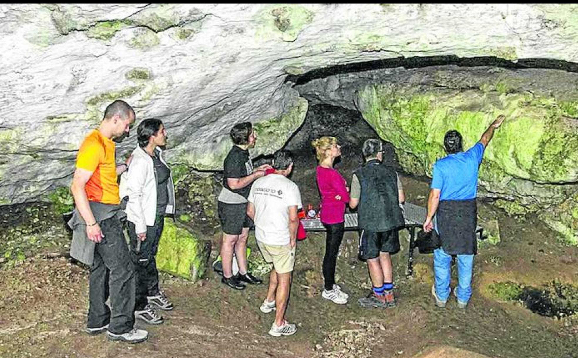 Un guía explica los detalles de la cavidad a un grupo de visitantes. 