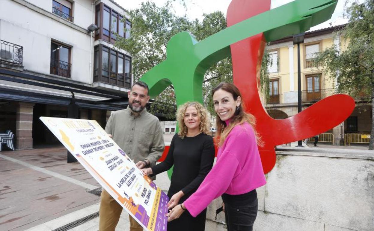 De izquierda a derecha, la director del festival, Manuel Gutiérrez, la concejala de Festejos, Patricia Portilla, y la directora general de Turismo, Marta Barca posan con el cartel, este miércoles, en Torrelavega. 