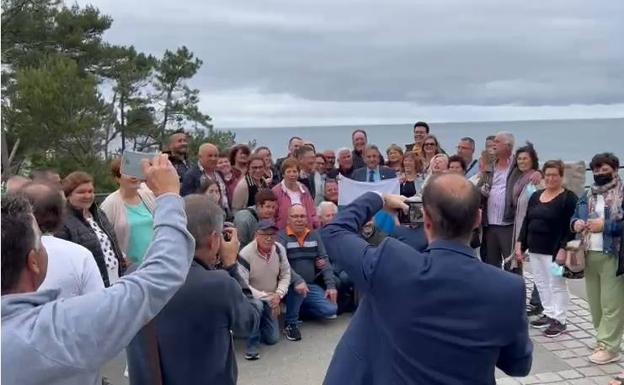 Casi 50 personas han rodeado al presidente para sacarse fotos con él junto a la bandera de Canarias.