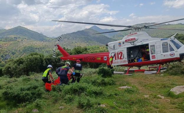 Técnicos y sanitarios trasladan al hombre de 79 años al helicóptero.