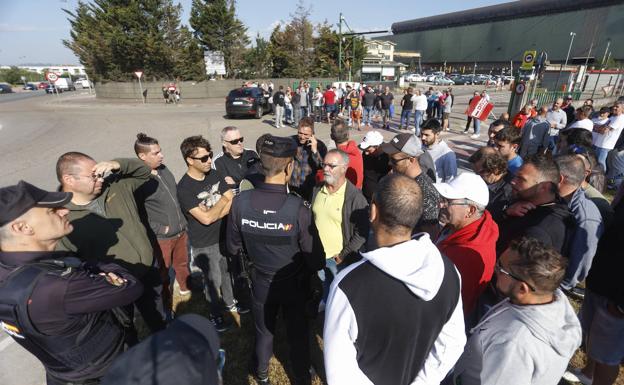 Un agente de la Policía Nacional habla con un delegado sindical esta mañana en la Global en Santander, donde se han concentrado los trabajadores desde las cinco de la mañana.