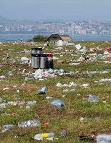 Imagen secundaria 2 - Imagen de las tiendas de campaña y los coches aparcados en el recinto de Ajo y de toda la basura que quedó al día siguiente.