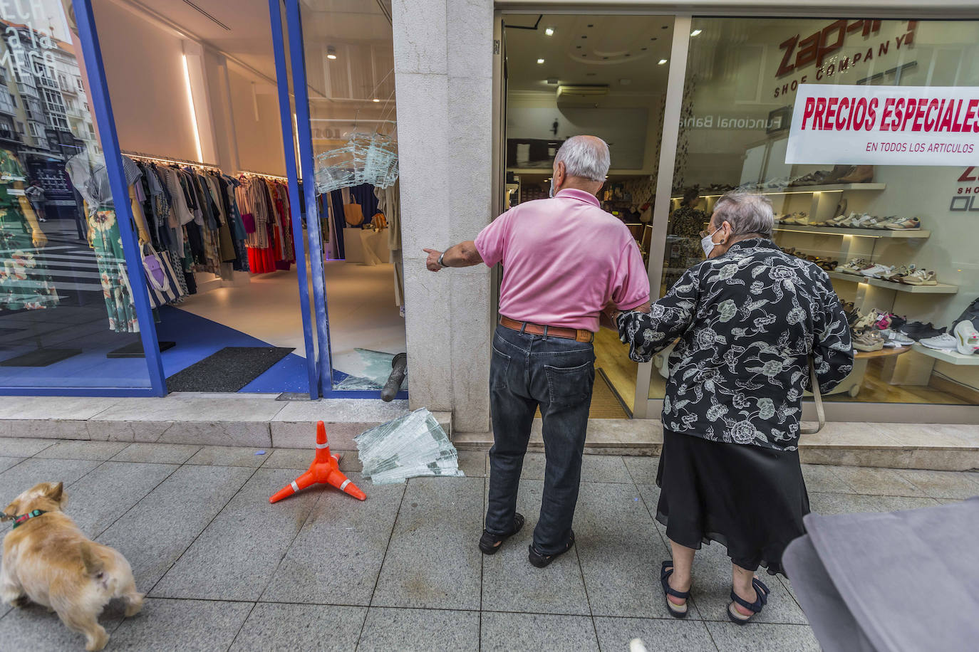 Ciudadanos asombrados con el destrozo en la tienda de ropa.