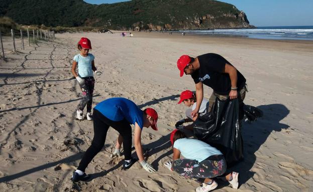 Imagen de archivo de voluntarios recogiendo residuos en la playa de Berria del municipio de Santoña.