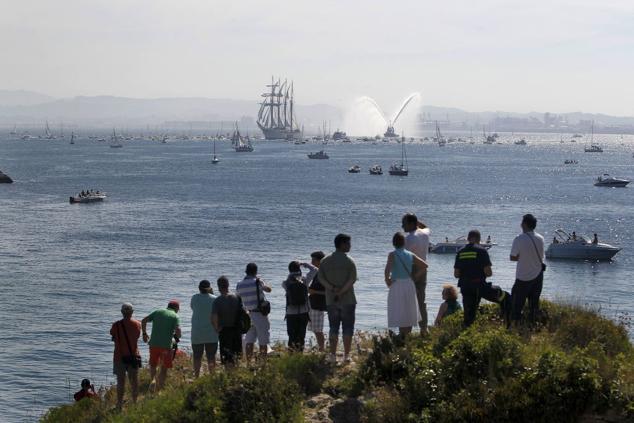 El buque sale de la bahía de Santander con las velas desplegadas escoltado por barcos de recreo.