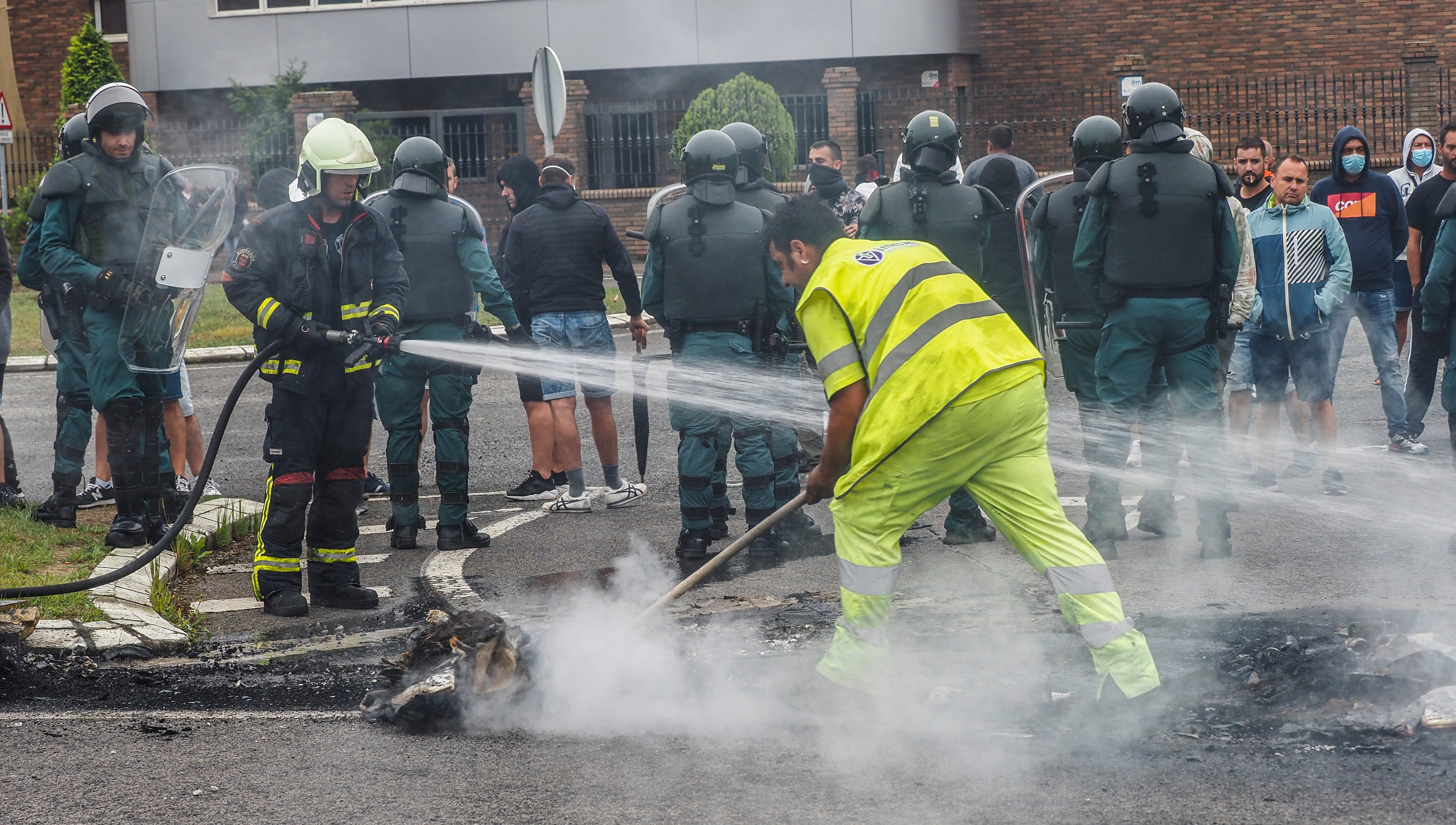 Los bomberos apagan el fuego de las barricadas de Guarnizo.