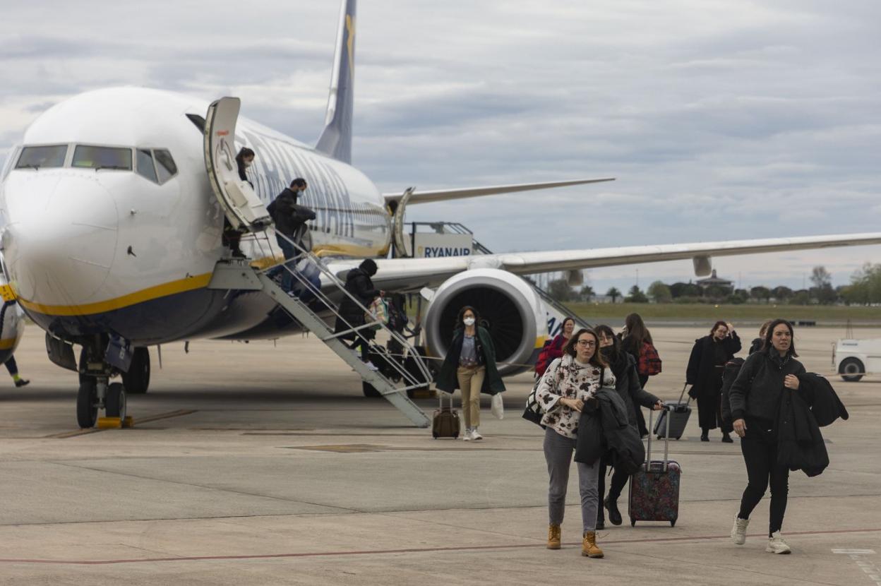 Un grupo de viajeros desciende de un avión de Ryanair en la pista del aeropuerto Seve Ballesteros.