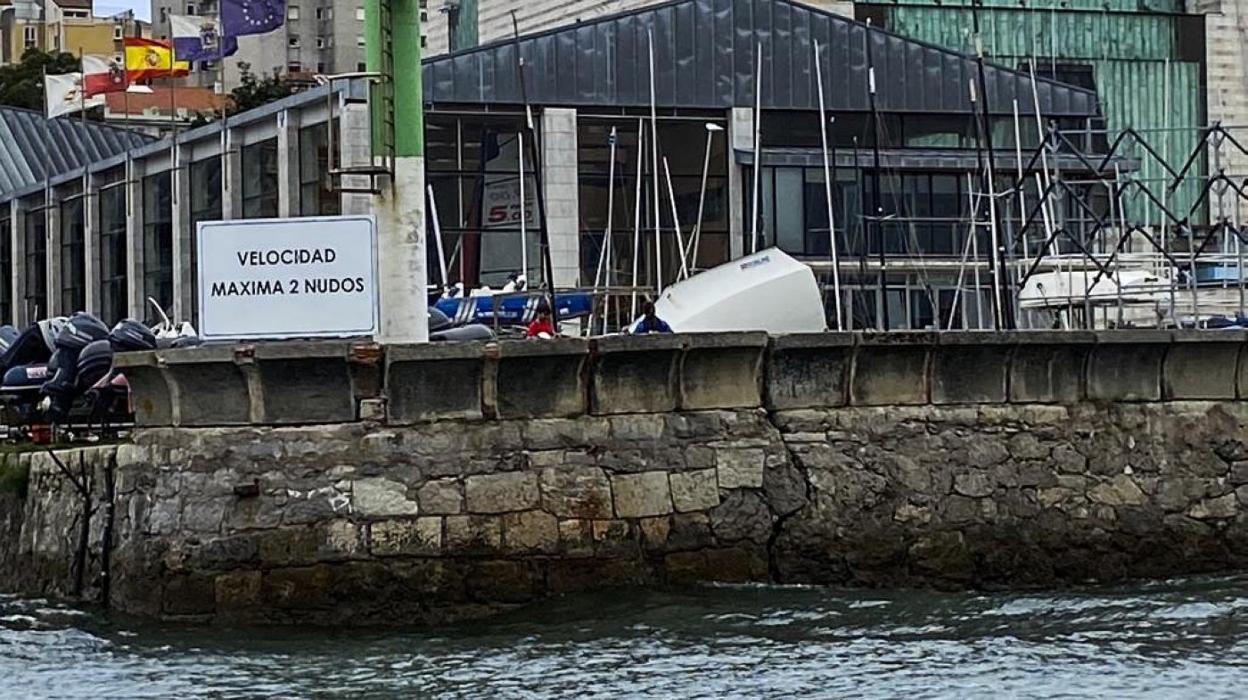 Una grieta parte en dos el muro de la dársena donde está instalado el CEAR de vela, a la entrada de Puertochico.