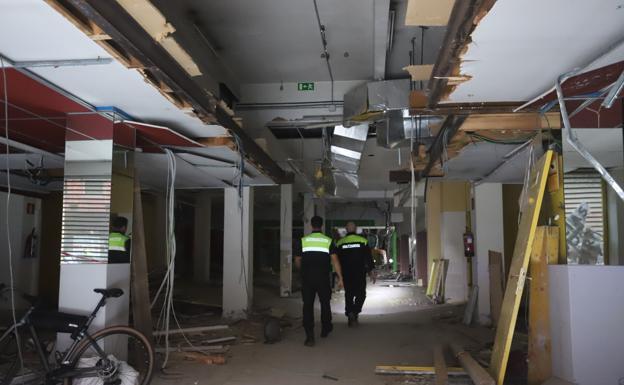 Imagen principal - Arriba, estado del interior del edificio. Abajo, algunas familias durante el desalojo y una de las ambulancias que acudieron a socorrer al herido. 