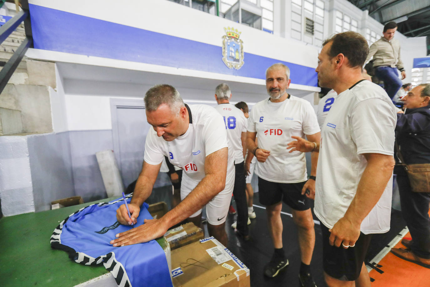 Chechu Fernandez, Chechu Villaldea y Domínguez firman una camiseta.