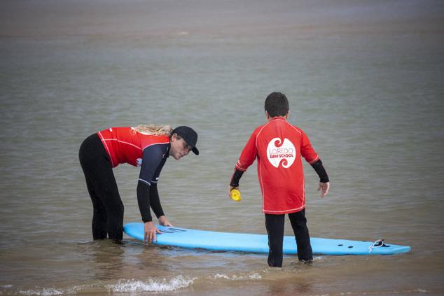 Tras los ejercicios previos, los niños entran en el mar acompañados por el monitor.