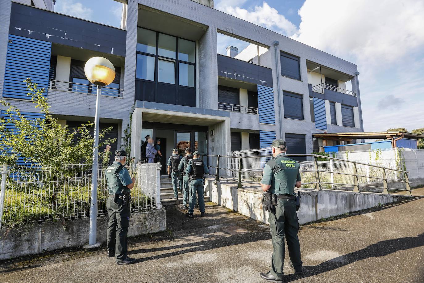 Agentes de la Guardia Civil en el instante previo al acceso a uno de los bloques de la urbanización.