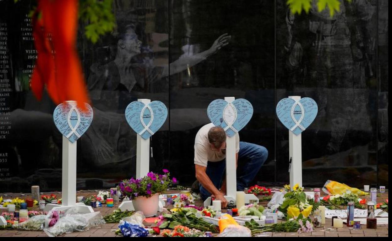 Un hombre realiza una ofrenda floral por las víctimas.