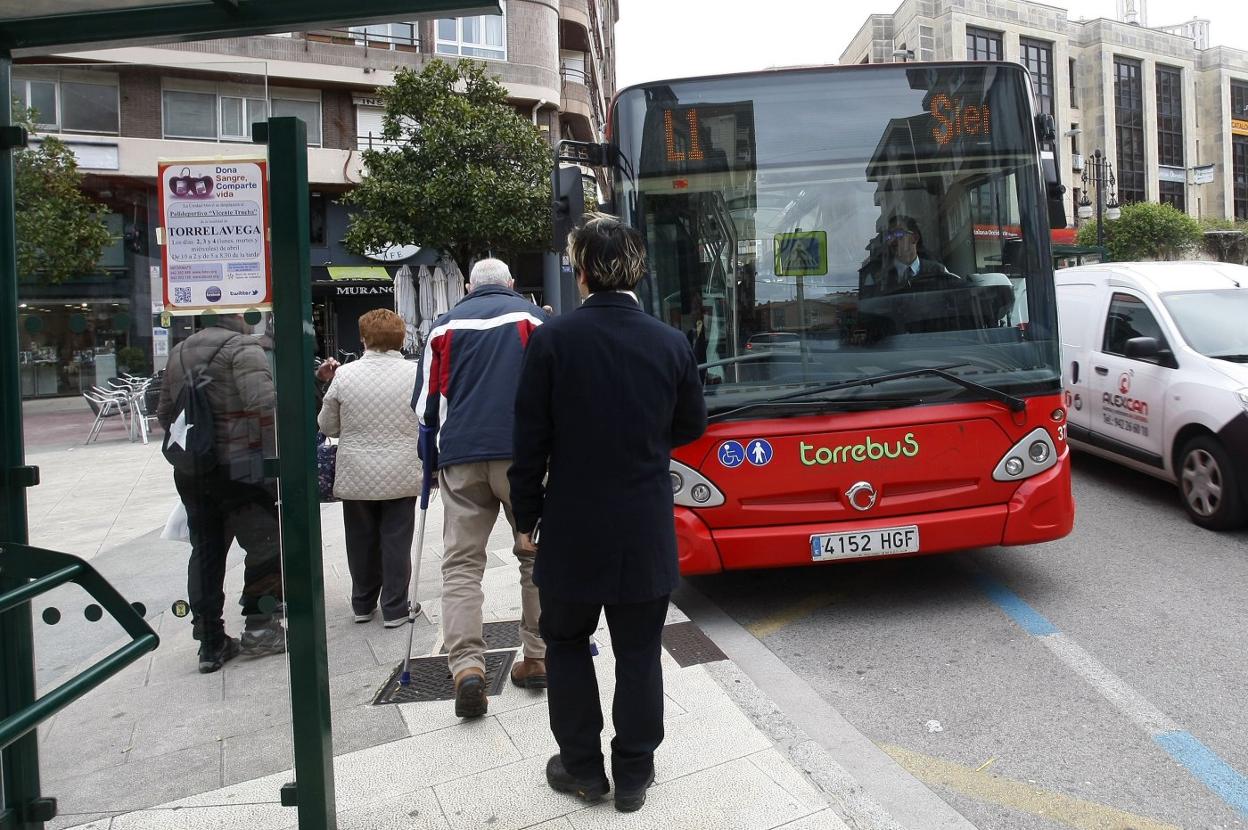 Usuarios agradan el servicio de transporte urbano en una parada.