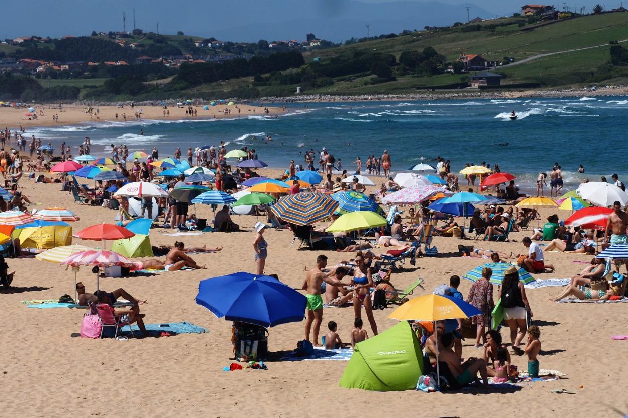 La playa de Valdearenas, en Liencres, llena ayer de gente disfrutando del fin de semana de sol y calor.