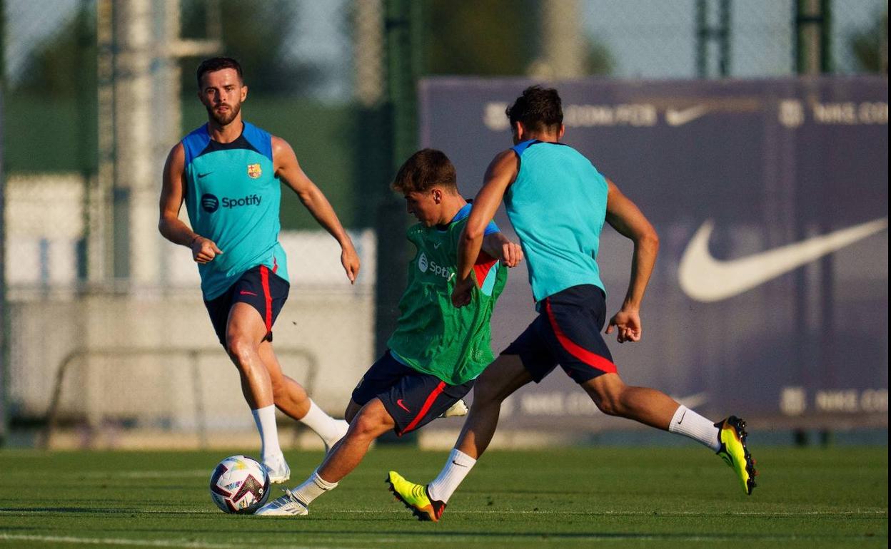 Pablo Torre se dispone a golpear el balón ante la mirada de Pjanic durante un entrenamiento con el Barcelona.