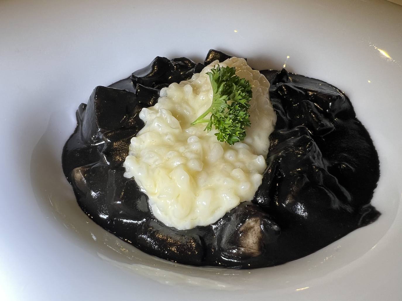 Cachón en su tinta con arroz. La cocina de Burdo, en Liencres, no pasa desapercibida para el cliente que valora la frescura y calidad del producto y el tratamiento exquisito y elegante del mismo para conseguir el máximo de matices de sabor y textura en la mesa. Este restobar, que inició su andadura en agosto de 2018 y que ha tenido que luchar a brazo partido contra los efectos de la pandemia -entre otros, siete meses de cierre-, ha conseguido, sin embargo, consolidarse con un referente por su interesante propuesta gastronómica en la que la parrilla juega un papel clave.