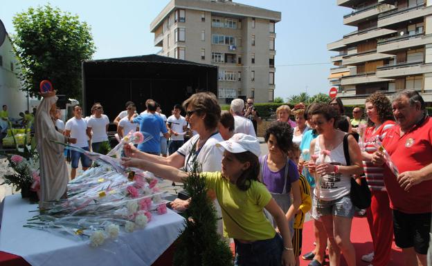 Los vecinos de Santoña participan en una ofrenda floral a la Virgen.