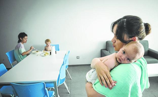 Imagen principal - En la primera foto Yuliia Bahdadarian intenta dormir a su bebé de cinco meses. En la segunda, Helena Yefymenko, junto a su hijo Cristian, prepara la comida. Y en la tercera aparece Rodica Saraju, trabajadora y tradcutora de Cruz Roja, que atiende a los refugiados desde su llegada en marzo.