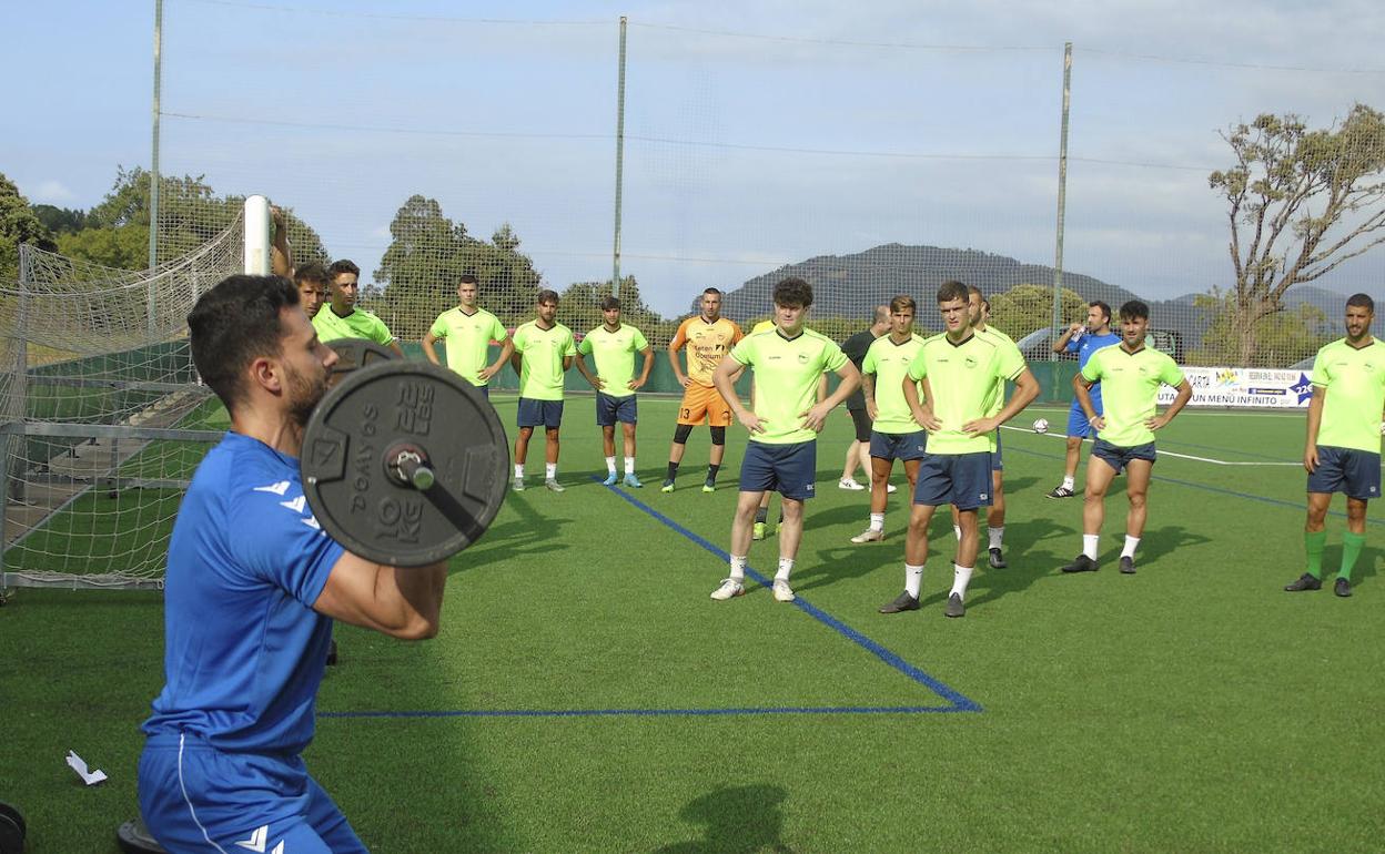 El preparador del Laredo, Jaime San Román, levanta peso ante los jugadores en el primer entrenamiento de esta pretemporada que se inició este miércoles.