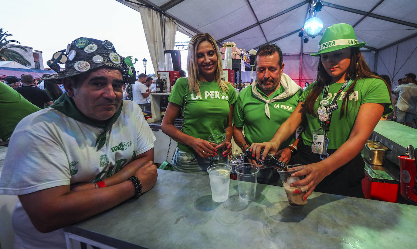 Integrantes de La Pera sirviendo bebidas dentro de la carpa de la peña. 