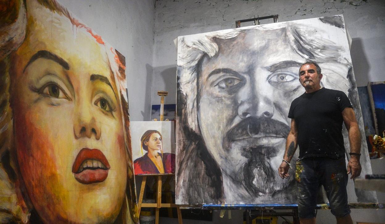 Luis Burgos, en su estudio, con sus obras. 