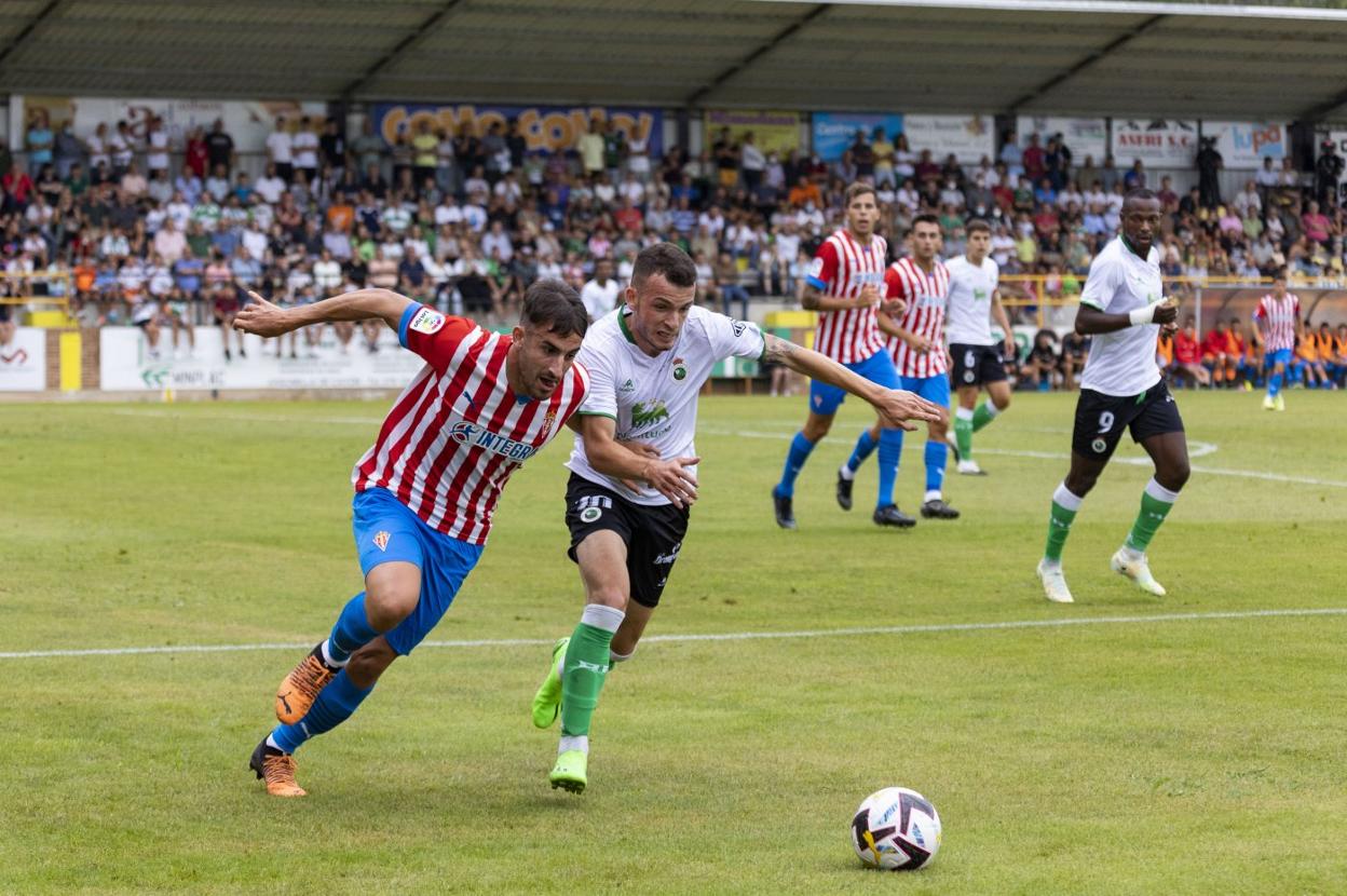 Íñigo Vicente pugna por el balón con un jugador del Sporting en el partido en Sarón donde debutó como verdiblanco. 