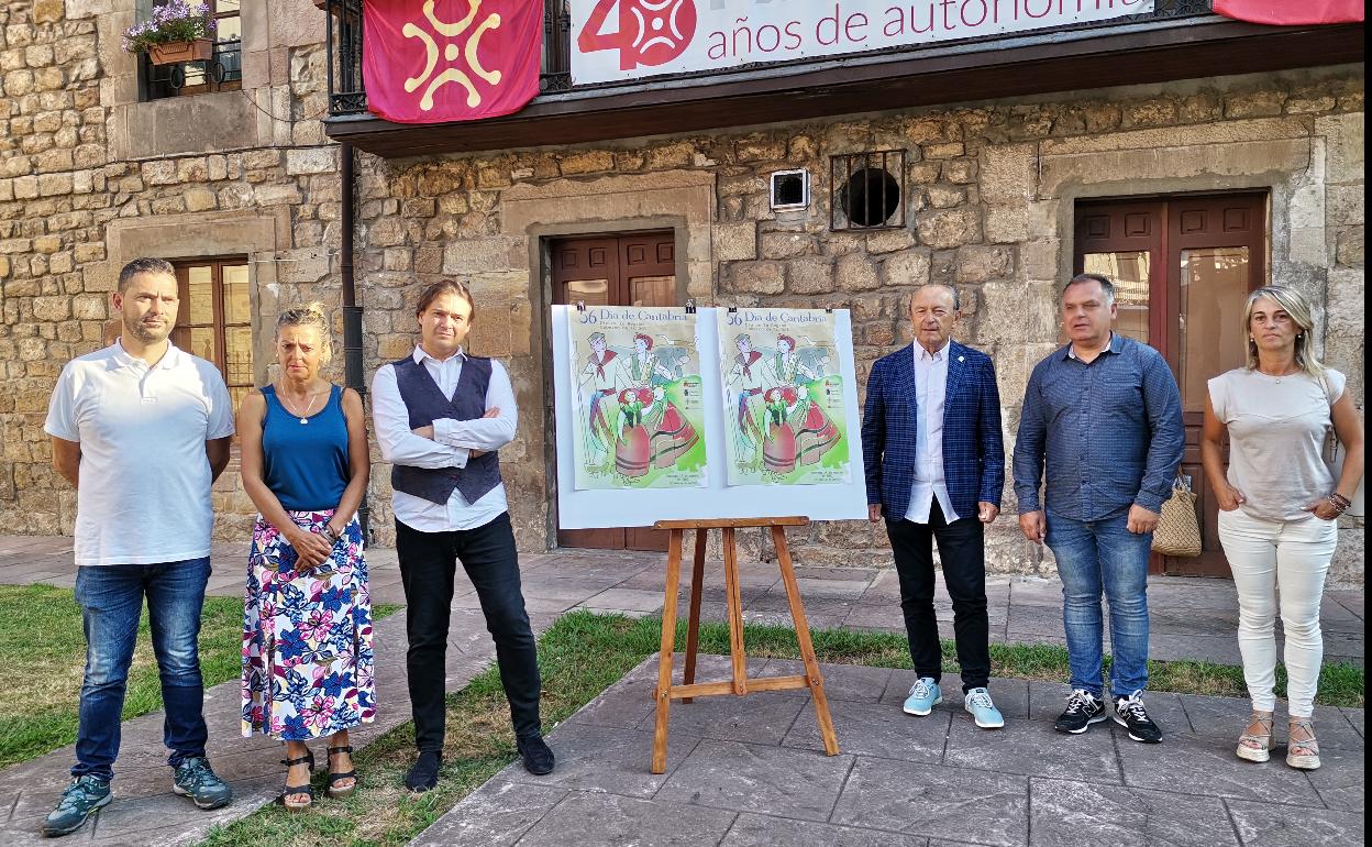 El consejero de Turismo y el alcalde de Cabezón de la Sal presentan junto a varios concejales el cartel ganador de las fiestas del Día de Cantabria, realizado por el ilustrador José Aguilar García. 