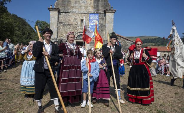 Personas ataviadas con sus trajes de pasiegos posando frente al Santuario de Nuestra Señora de Valvanu