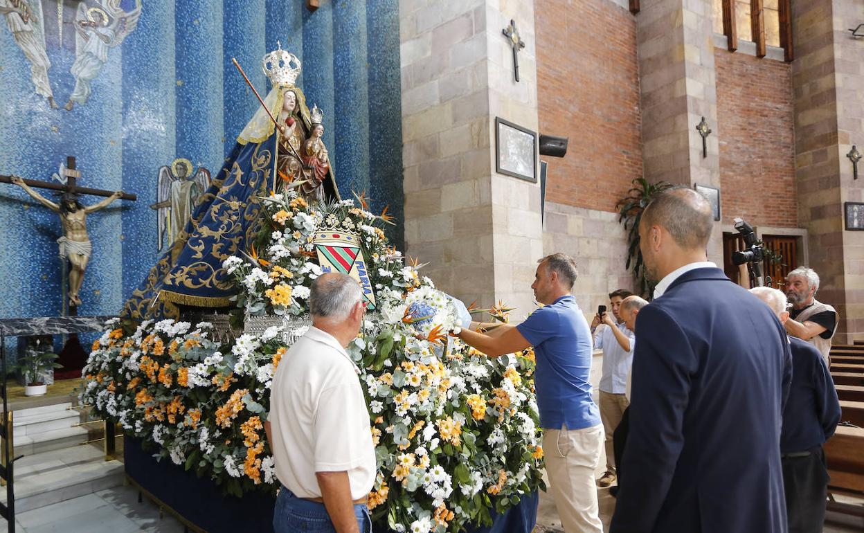 El presidente de la Gimnástica, Siro del Barrio, ofrece un ramo de flores a la patrona.