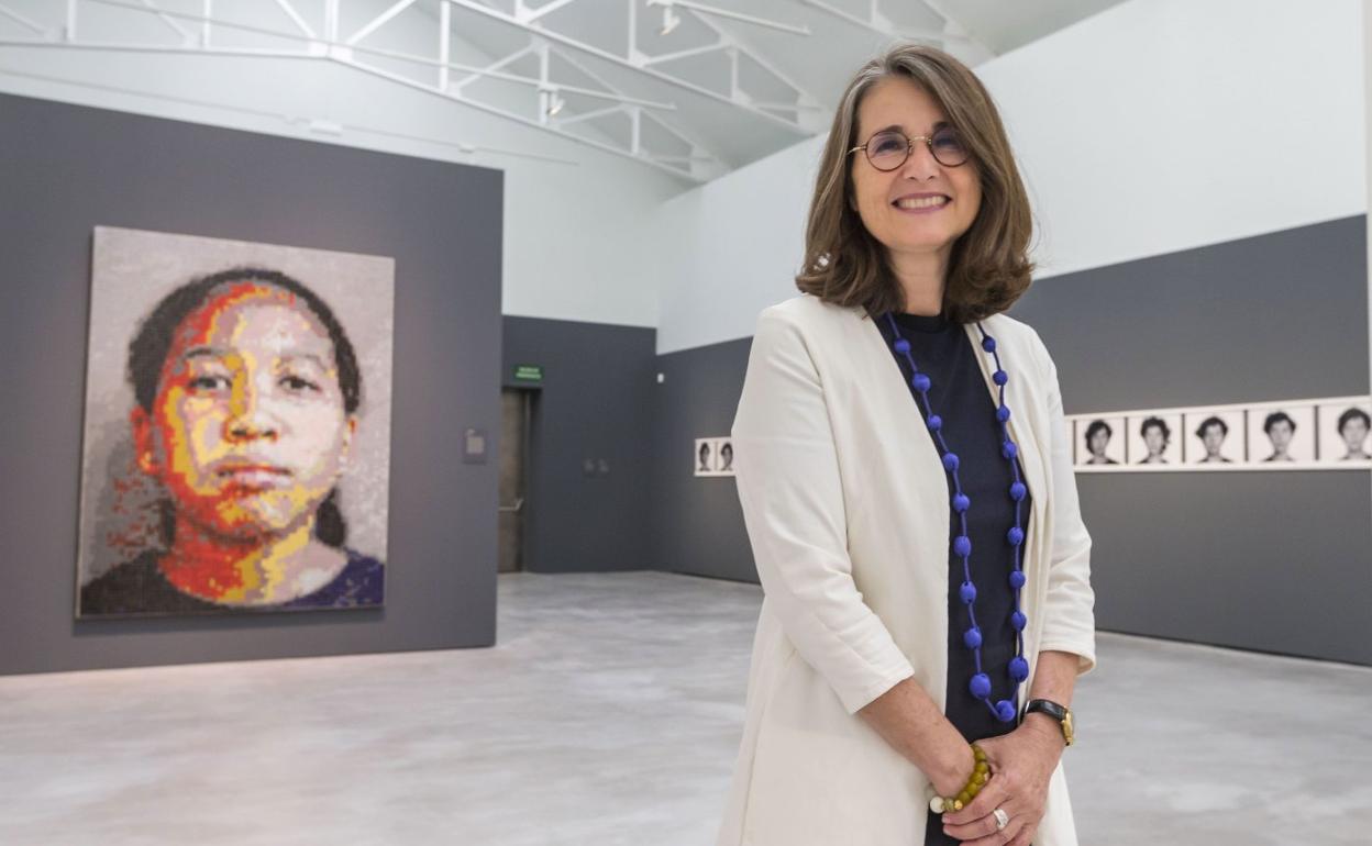 Nimfa Bisbe, en la sala de exposiciones de las Naves de Gamazo, junto a una de las obras 'Amber Smoot' que forman parte de la exposición.