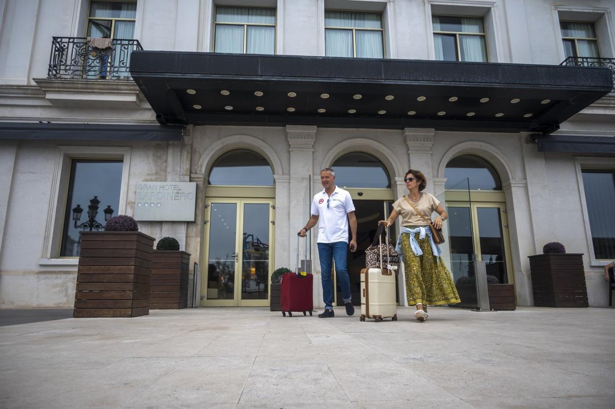 Una pareja de turistas, ayer, sale del Gran Hotel Sardinero, en la Plaza de Italia de Santander, tras pasar unos días en la ciudad. 